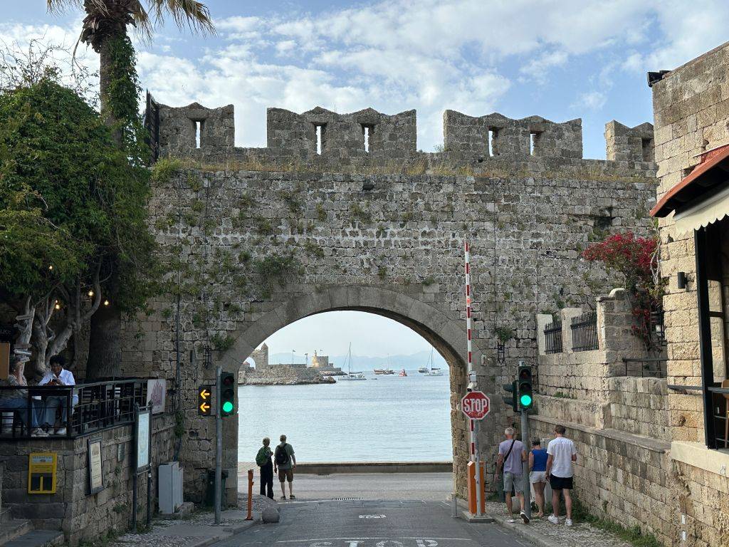 Blick auf das historische Tor „Pili Panagias“ in der mittelalterlichen Altstadt von Rhodos mit traditionellen Gassen und Steinmauern.